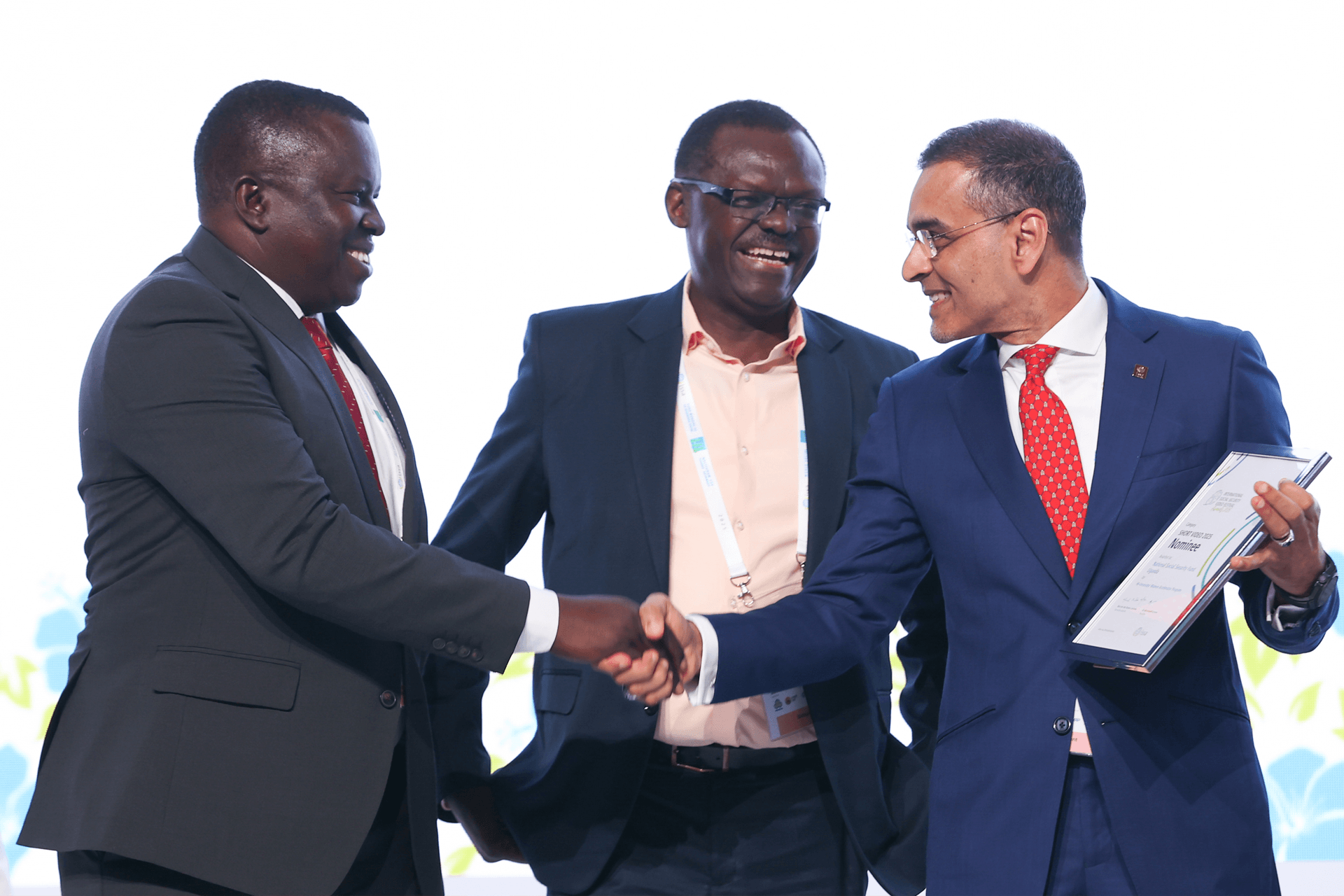 The NSSF Board Chairman David Ogong (left) and NSSF Managing Director Patrick Ayota (centre) receive the award for the winner under the Short Video category of the first-ever International Social Security Video Festival and Awards at the World Social Security Forum in Kuala Lumpur, Malaysia, in September 2025.