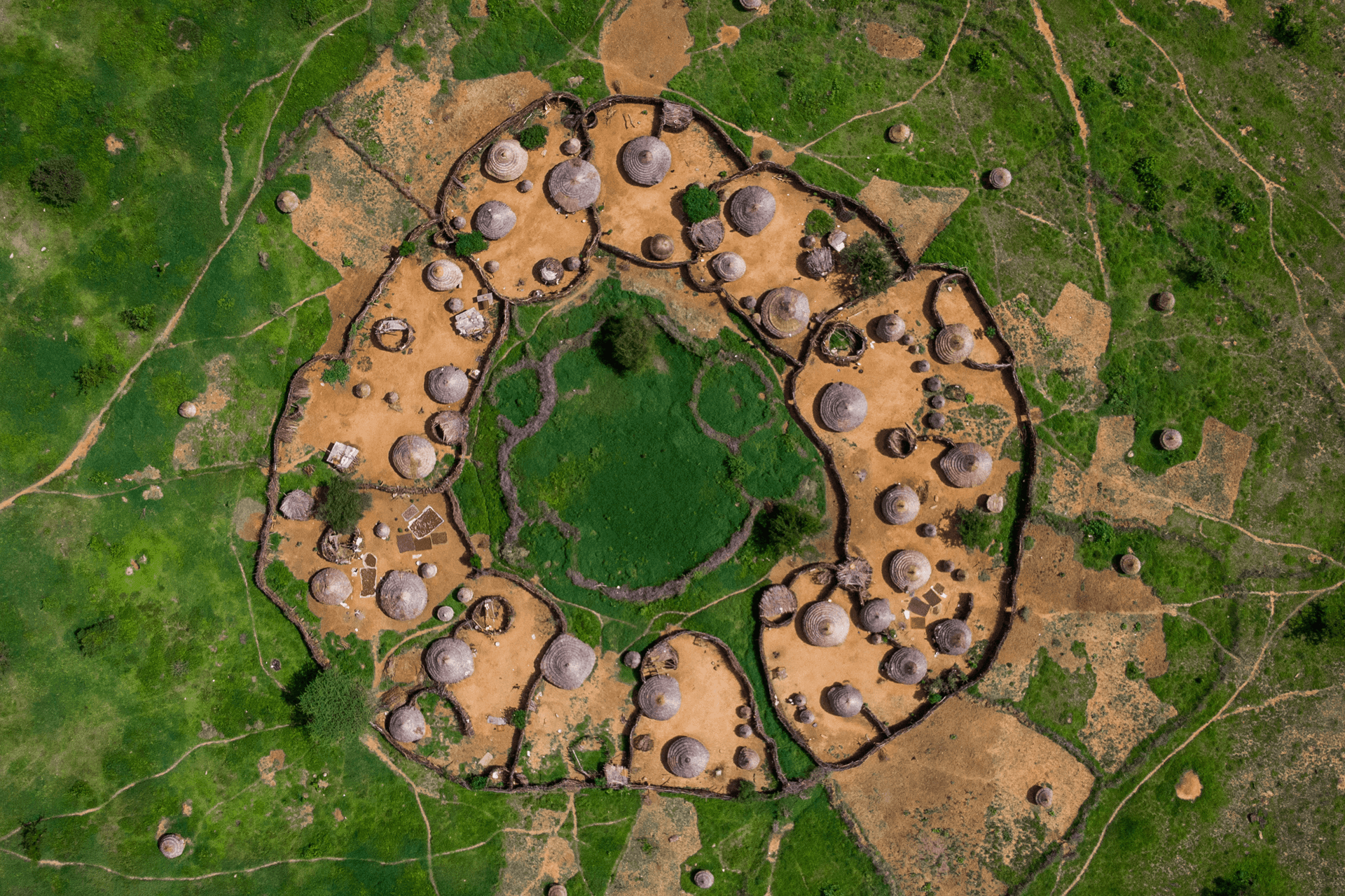 Aerial view of a circular rural settlement surrounded by green land
