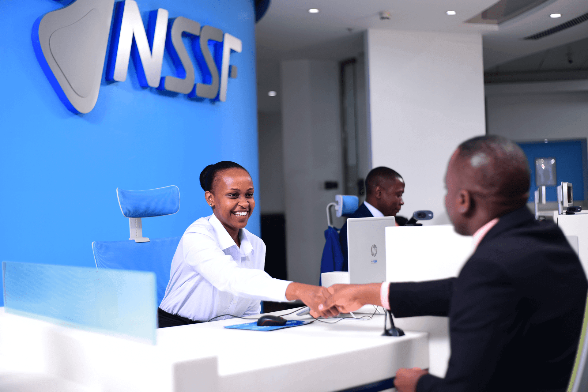 An NSSF employee assisting a member at a service desk