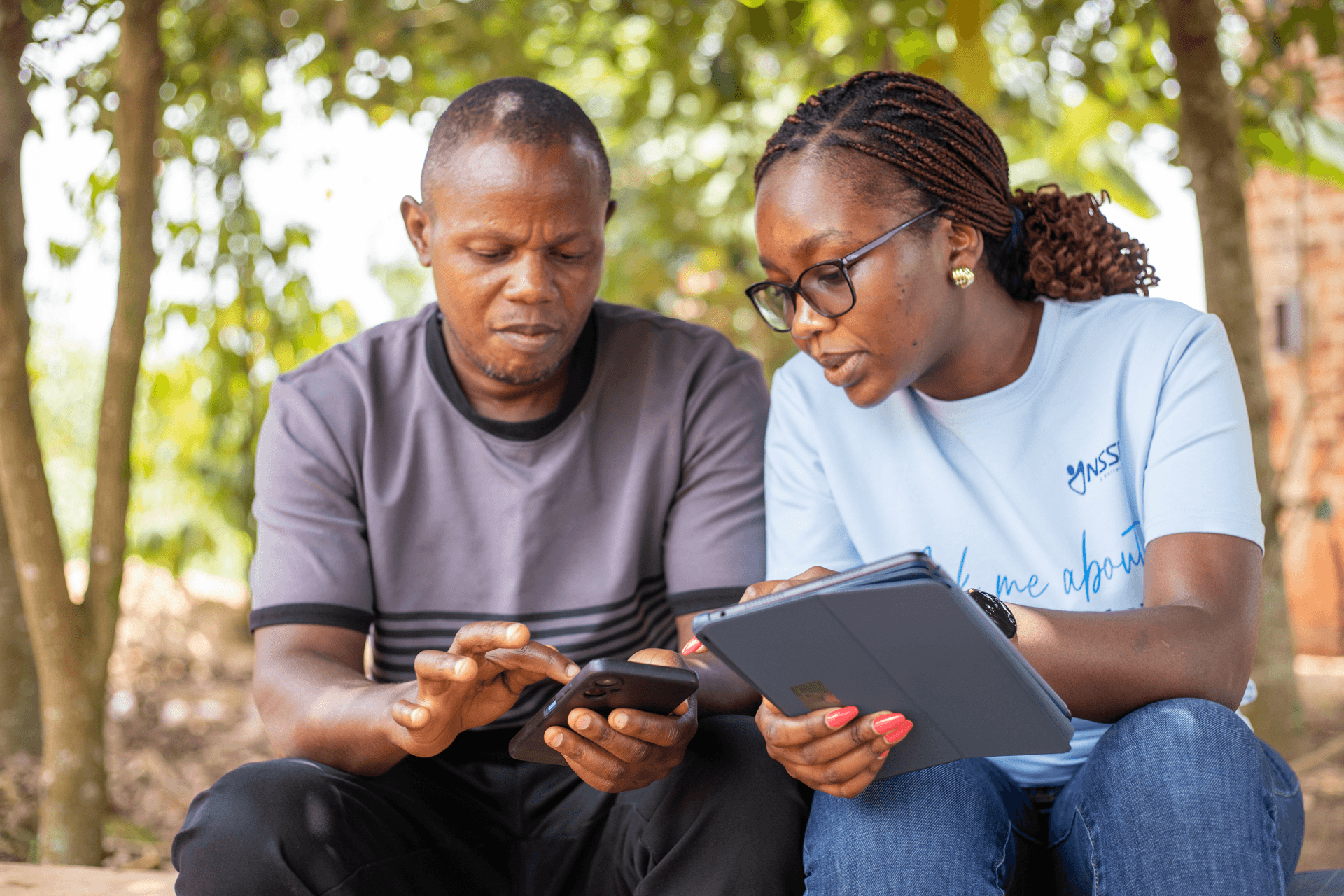 Two people reviewing information on a tablet