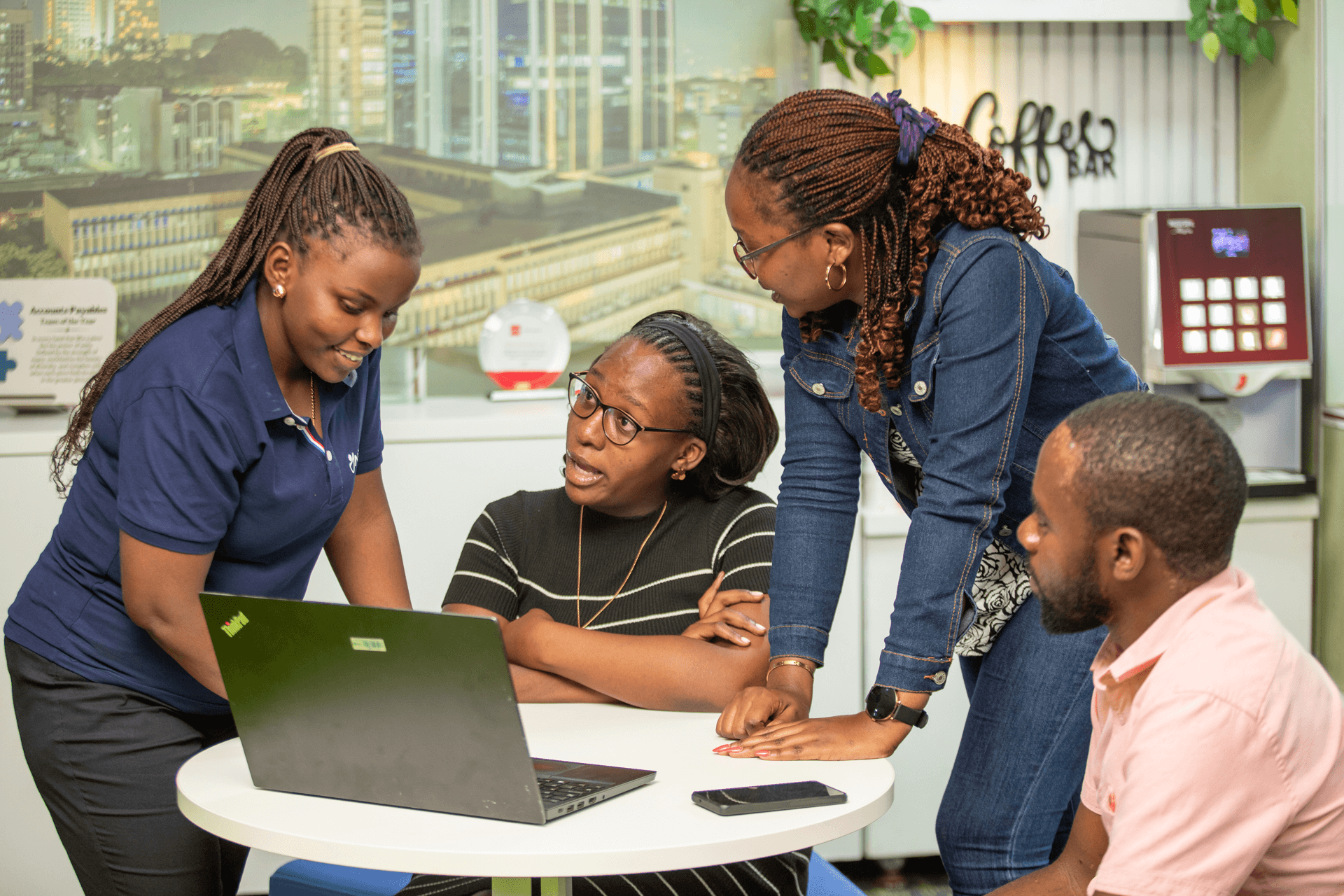 Colleagues collaborating around a laptop